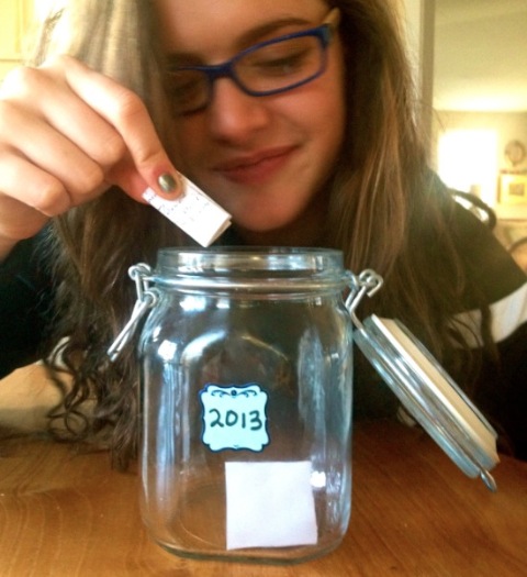 Photo of daughter dropping a happiness note into the 2013 Happiness Jar . THis post is published on I Love You often...just not always blog about love and relationships.